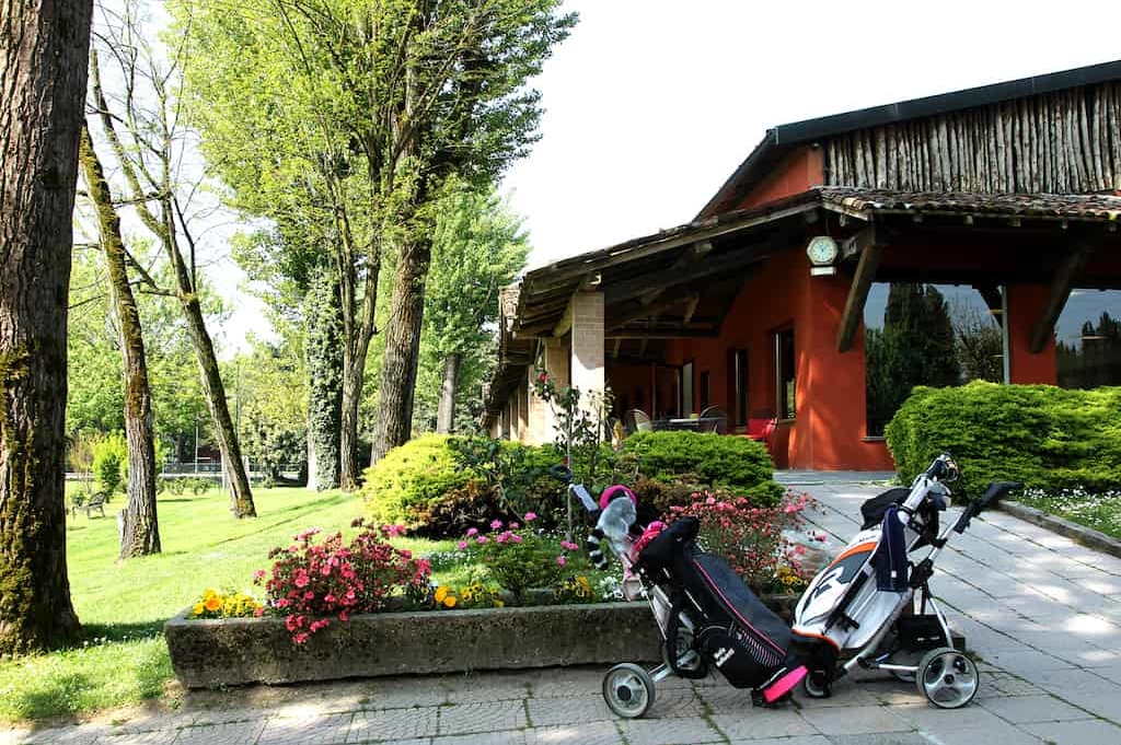 vista-posteriore-club-house-con-sacche-da-golf-min vista-posteriore-club-house-con-sacche-da-golf-min